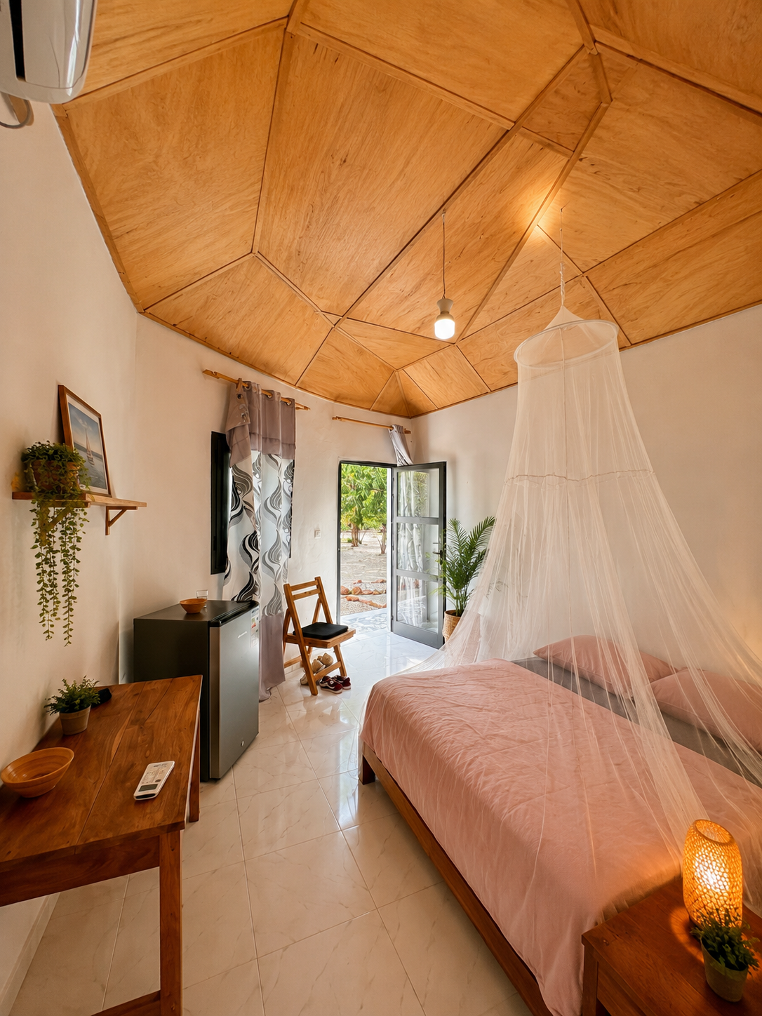 Habitación privada de Chez Dominique en Missirah, Senegal, con cama, mosquitera, aire acondicionado, nevera y estilo natural